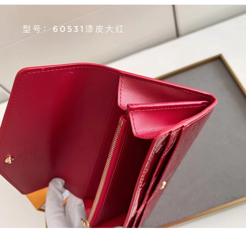 Una cartera roja y marrón dice LOUIS VUITTON con iniciales 'LV', Medidas:  40cm de largo x 22 cm de a