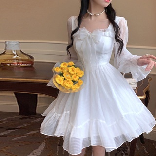 Elegante mujer joven delgada en vestido blanco